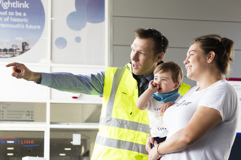 Wightlink staff member at Portsmouth Gunwharf port helps a customer